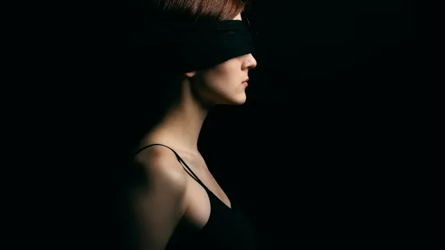 Frau mit schwarzer Augenbinde im Profil – echte BDSM-Sexgeschichte