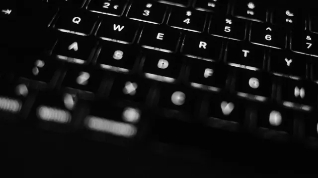 Beleuchtete Laptop-Tastatur im Dunkeln – Joyclub oder FetLife im Vergleich