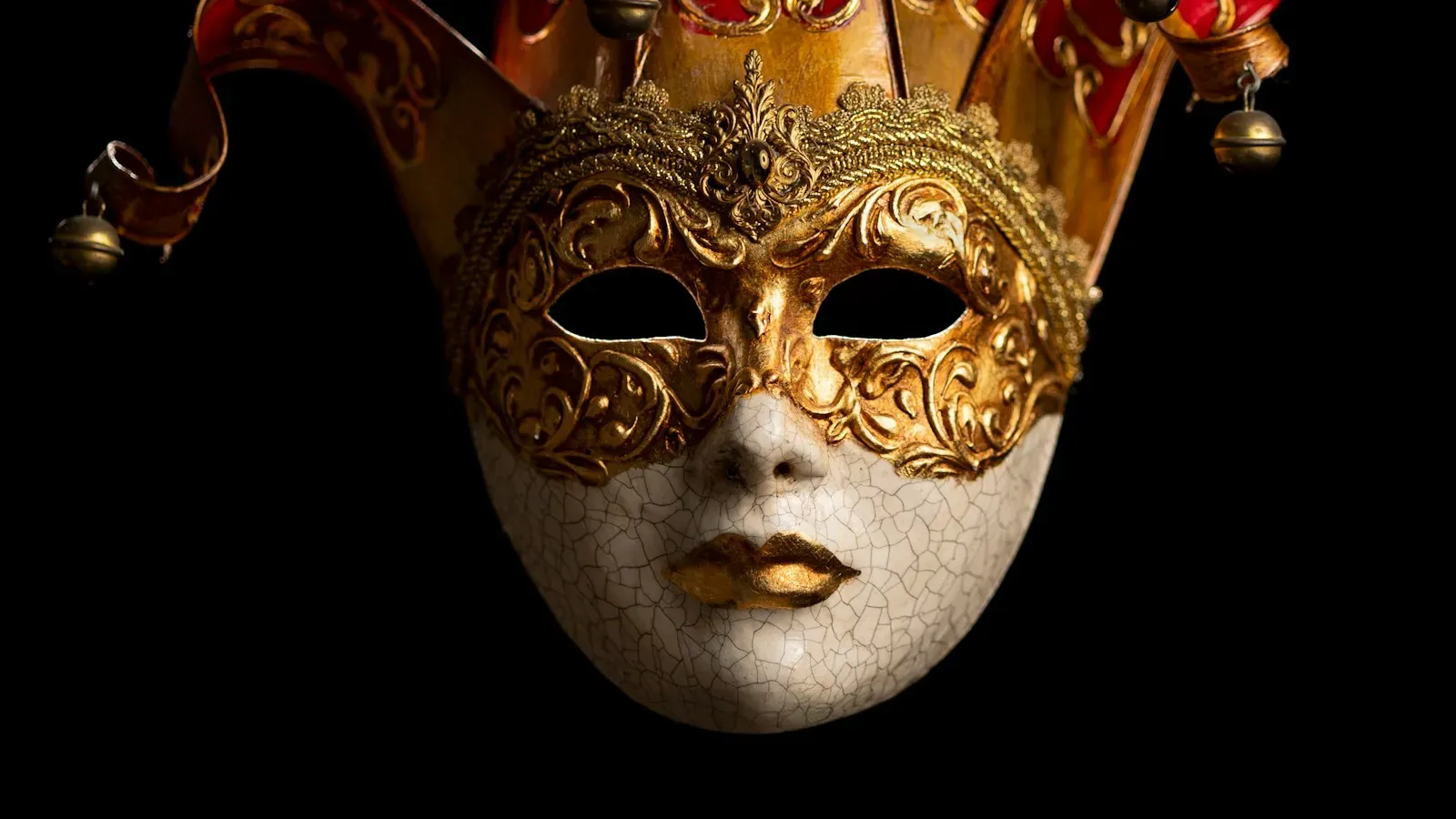 Venezianische Maske mit goldenen Verzierungen vor schwarzem Hintergrund – BDSM-Rollenspiele im Chat