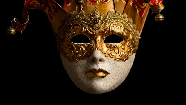 Venezianische Maske mit goldenen Verzierungen vor schwarzem Hintergrund – BDSM-Rollenspiele im Chat